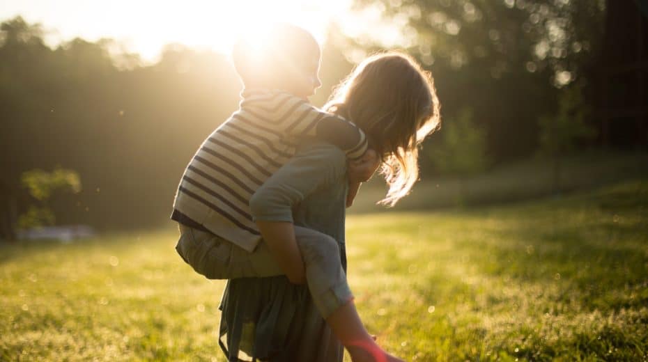 Girl giving piggy back ride to younger child