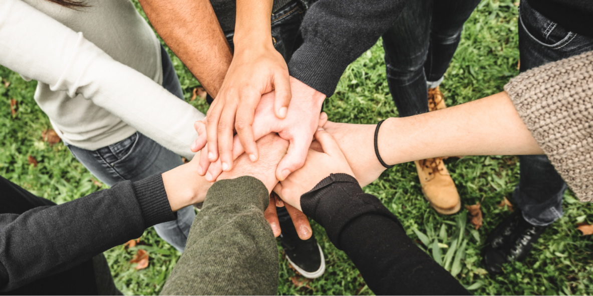 a group of people put their hands in during a huddle
